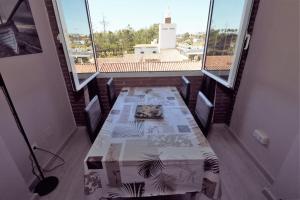 Zimmer mit einem Tisch in einem Zimmer mit Fenstern in der Unterkunft Apartamento La Cordobesita in San Luis de Sabinillas