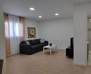 uma sala de estar com um sofá e uma mesa em b Apartamentos Diego em O Grove