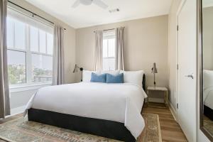 a bedroom with a large white bed with blue pillows at Sonder at LC SoBro in Nashville