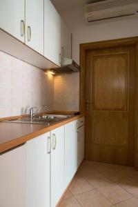 a kitchen with a sink and a wooden door at House Vera in Baška Voda