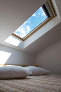 a skylight in a bedroom with a bed and a pillow at House Vera in Baška Voda