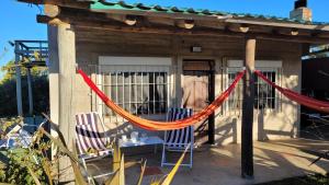 a porch with two chairs and a hammock at Campomar in Balneario Buenos Aires