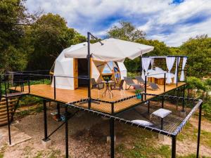 a yurt with a table and chairs on a deck at Glamping Girardot & Hotel Puerta Del Sol Girardot in La Virginia