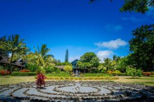 un giardino con un orologio al centro di Lumeria Maui, Educational Retreat Center a Makawao
