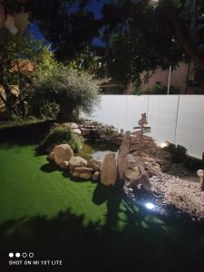 um jardim com um lago e pedras num quintal em Albero della vita em Spotorno