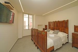 a bedroom with a large bed with a wooden headboard at DIMORE DEL CENTRO - Domus Coeli in Salò