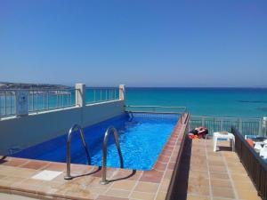 a swimming pool on top of a building with the ocean at Hotel Marina Playa De Palma in El Arenal