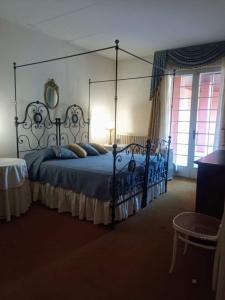 ein Schlafzimmer mit einem Himmelbett und blauen Kissen in der Unterkunft La dama con l'ermellino B&B in San Zavedro