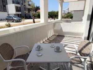 - Balcón con mesa blanca y sillas en Albedo - Charming Apartment with Amazing Location, en Tivat