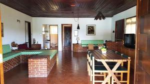 sala de estar con mesa y bancos verdes en Casa de campo c piscina e churrasq - Mairipora - SP, en Mairiporã