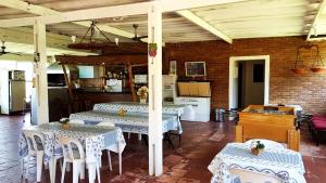 comedor con 2 mesas y cocina en Casa de campo c piscina e churrasq - Mairipora - SP, en Mairiporã