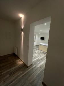 um quarto vazio com uma cama e pisos em madeira em Linus und seine Ferienwohnungen em Heldrungen