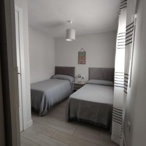 a bedroom with two beds and a hallway at AniCa I, en el corazón de la Mancha in Argamasilla de Alba