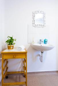 a bathroom with a sink and a table with a plant at Room near to Birmingham city centre with parking in Birmingham