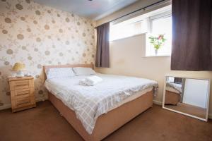 a bedroom with a bed and a window and a mirror at Room near to Birmingham city centre with parking in Birmingham