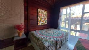 una camera con un letto in una stanza con finestra di Eco Paradise Muriqui a Mangaratiba