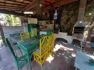 tavolo e sedie verdi in una stanza con piano cottura di Eco Paradise Muriqui a Mangaratiba