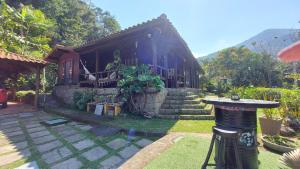 ein kleines Haus mit einem Tisch davor in der Unterkunft Eco Paradise Muriqui in Mangaratiba