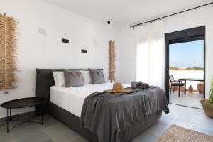 a bedroom with a large bed and a balcony at Seasand Villa in Lachania