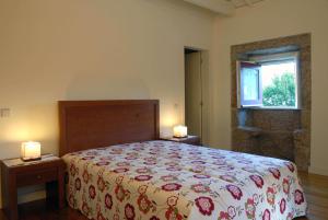 ヴィエイラ・ド・ミーニョにあるAldeia Turistica de Louredoのベッドルーム1室(ベッド1台、テーブルにランプ2つ付)