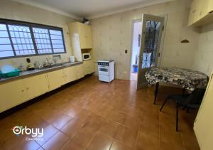 een keuken met een wastafel en een tafel in een kamer bij Ritz Hostel in Araçatuba