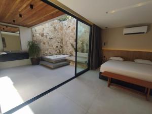 1 dormitorio con cama y pared de piedra en Motel UP (Adult Only), en Fortaleza