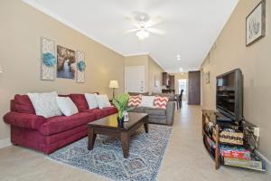 ein Wohnzimmer mit einem roten Sofa und einem TV in der Unterkunft The Dawn Oceanfront Condo on Seawall Blvd in Galveston