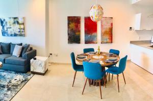a dining room with a table and blue chairs at Camino Al Mar with Amazing View of the Ocean, Beach and Pool in Mazatlán