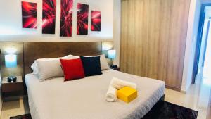 a bedroom with a large white bed with colorful pillows at Camino Al Mar with Amazing View of the Ocean, Beach and Pool in Mazatlán +43 photos