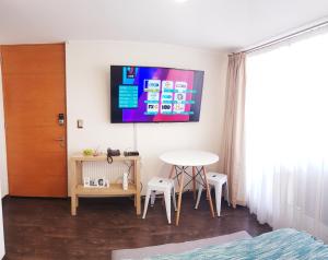 Una habitación con una mesa y un televisor en la pared. en Departamento Central Uno Norte Viña del Mar, en Viña del Mar