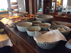 a buffet with many baskets of food on a table at Hotel de Admiraal in Noordwijk aan Zee