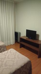 a hotel room with two beds and a flat screen tv at 11 Peyret Rent Aparts in Colón