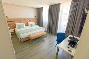 a hotel room with a bed and a table and chair at Hotel Mondego in Coimbra