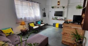 a living room with a couch and a tv at Quintal da Bella Hostel in Santos