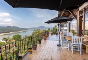 uma varanda com uma mesa e cadeiras e um guarda-sol em Hotel Santa Rosa em Valle de Bravo