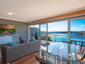 
a living room filled with furniture and a large window at Pacific Pines Unit 5 in Narooma

