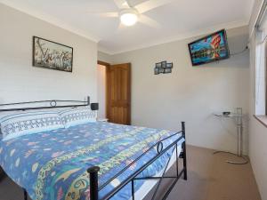 a bedroom with a bed and a ceiling fan at Pacific Pines Unit 5 in Narooma