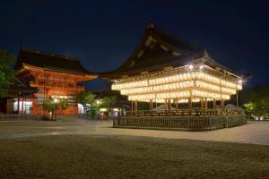 un grand bâtiment avec des lumières allumées la nuit dans l'établissement Ryokan Sanoya, à Kyoto