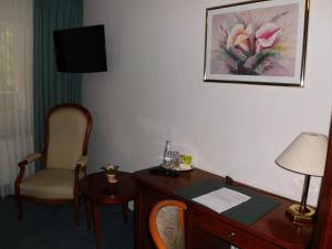 a hotel room with a desk and a chair at Parkhotel Schönewalde in Schönewalde
