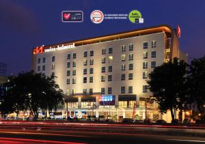a large building with lights on it at night at Swiss-Belhotel Airport Jakarta in Tangerang