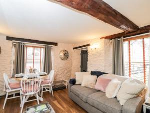 a living room with a couch and a table at Corner Cottage in Malmesbury