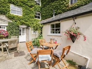 a patio with a table and chairs in front of a building at Corner Cottage in Malmesbury