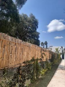una valla de madera junto a una acera y árboles en Hotel Posada La Bonita, en Tula de Allende