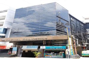 a large glass building with a store in front of it at Capital Residency in Bangalore