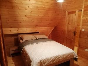 1 dormitorio con 1 cama en una cabaña de madera en Brvnare filip, en Nova Varoš