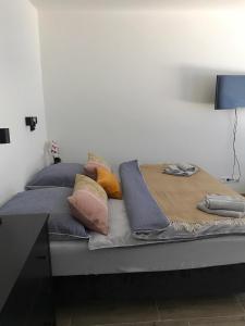 een bed met kussens in een kamer bij Varalja Apartments in Plavecké Podhradie