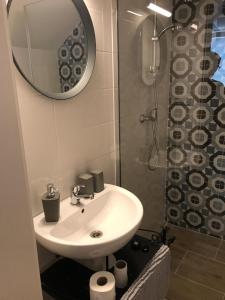 een badkamer met een wastafel en een douche met een spiegel bij Varalja Apartments in Plavecké Podhradie