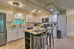 a kitchen with white cabinets and a island with bar stools at Modern East Stroudsburg Home with Deck and Gas Grill! in East Stroudsburg
