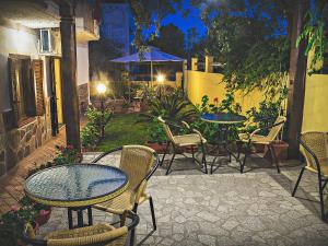 an outdoor patio with tables and chairs at night at Bed and Breakfast Ichnos in Cala Gonone