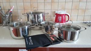 a group of pots and pans on a kitchen counter at Niebieski Meander Pokoje blisko metra in Warsaw